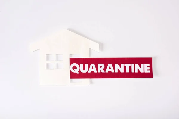 Top view of paper house near quarantine lettering on white — Stock Photo