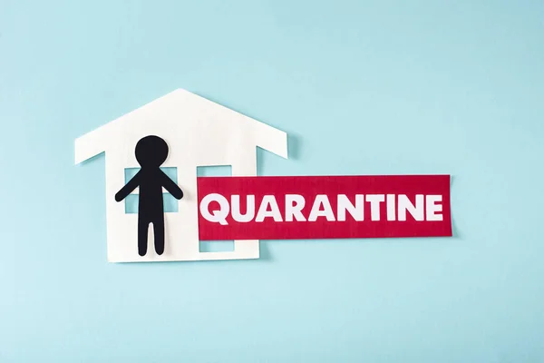 Top view of paper house and human near quarantine lettering on blue — Stock Photo
