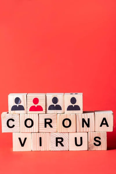 Cubos de madera con iconos de personas y letras coronavirus en rojo - foto de stock