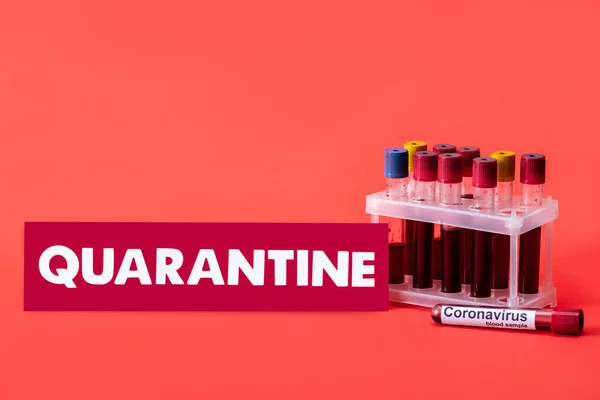 Provette con campioni di sangue vicino all'iscrizione di quarantena sul rosso — Foto stock