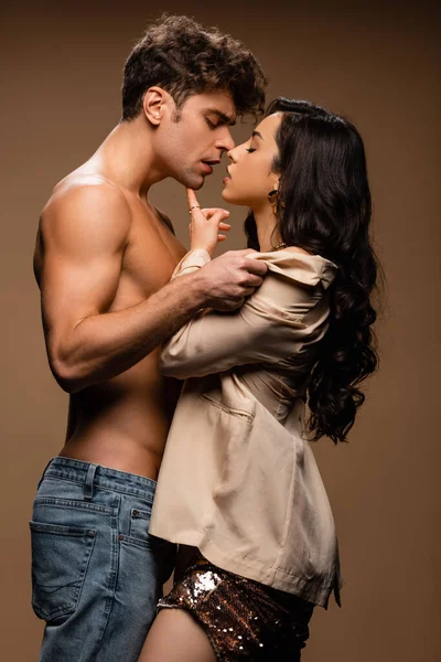 Passionné homme torse nu va embrasser sexy moitié femme nue en veste beige sur beige — Photo de stock