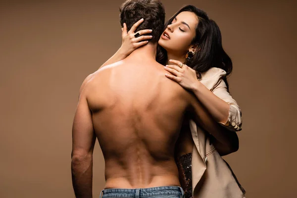 Vue arrière de l'homme torse nu et femme sexy en veste beige sur beige — Photo de stock