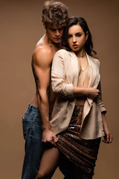 Passionate shirtless man and sexy half naked woman in beige jacket on beige — Stock Photo