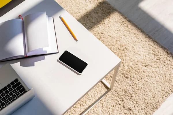 Empty workplace with laptop, smartphone and notepad — Stock Photo