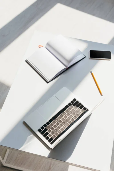 Posto di lavoro vuoto con laptop, smartphone, blocco note e matita — Foto stock