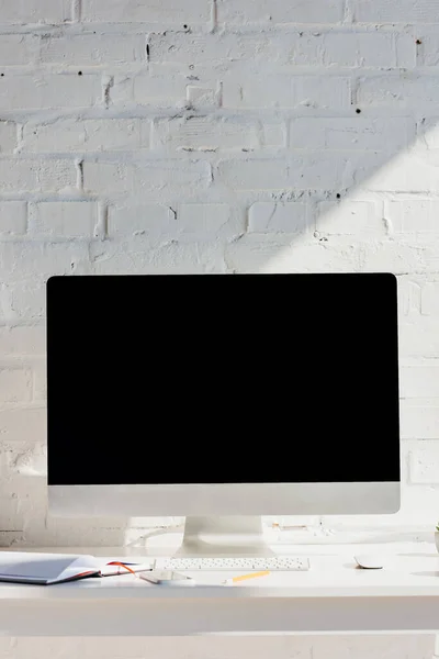 Oficina en casa con monitor de computadora con pantalla en blanco a la luz del sol - foto de stock