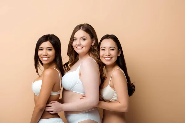 Allegro plus size multiculturale ragazze in reggiseni isolati su beige — Foto stock