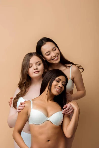 Cheerful plus size multicultural girls with closed eyes isolated on beige — Stock Photo