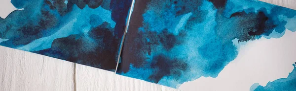 Vista superior de imágenes con pintura japonesa con acuarela azul sobre fondo de madera, plano panorámico - foto de stock