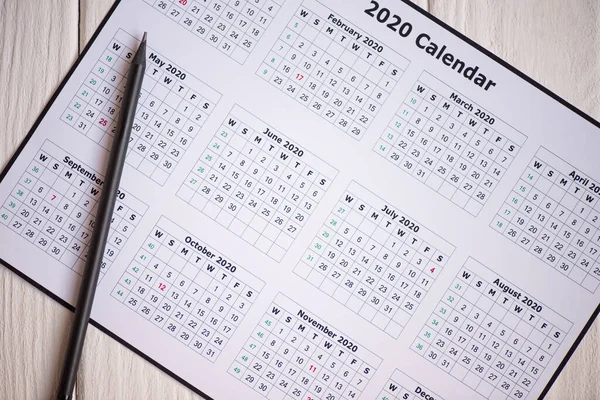 Vista superior do calendário 2020 e lápis sobre fundo de madeira — Fotografia de Stock