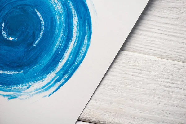 High angle view of paper with Japanese painting with blue watercolor on wooden background — Stock Photo