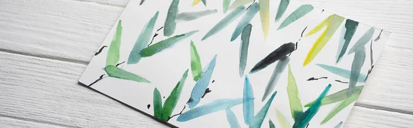 Vista superior de papel com pintura japonesa com folhas multicoloridas sobre fundo de madeira, tiro panorâmico — Fotografia de Stock