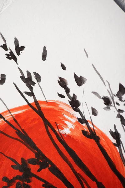 Vue du dessus du papier avec peinture japonaise avec soleil rouge et branches — Photo de stock