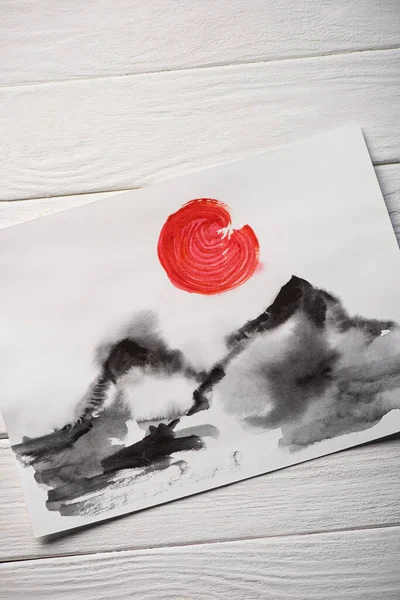 Vista superior de papel com pintura japonesa com colinas e sol vermelho sobre fundo de madeira — Fotografia de Stock