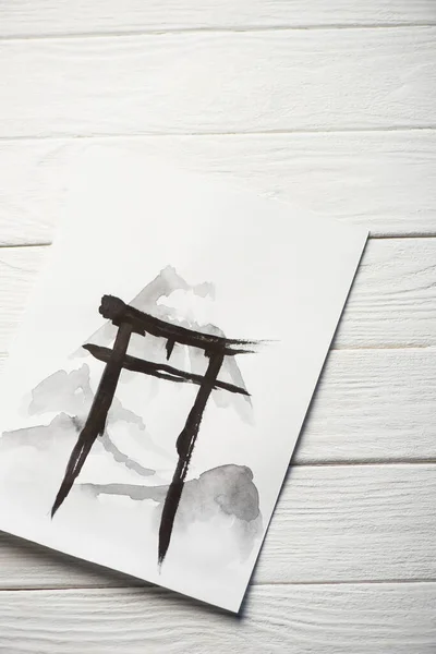 Top view of paper with japanese painting with black hieroglyph on wooden background — Stock Photo