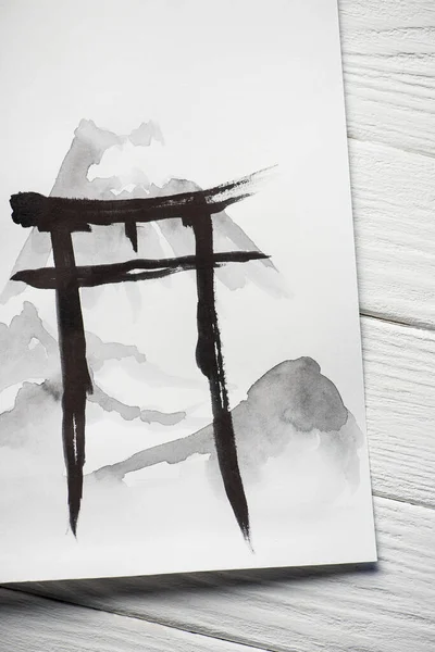 Top view of paper with painted black hieroglyph on wooden background — Stock Photo