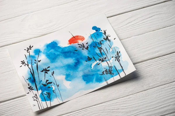 High angle view of paper with japanese painting with blue sky, branches and sun on wooden background — Stock Photo