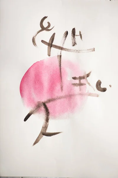 Верхній вид паперу з японським живописом з ієрогліфами на рожевому колі. — стокове фото