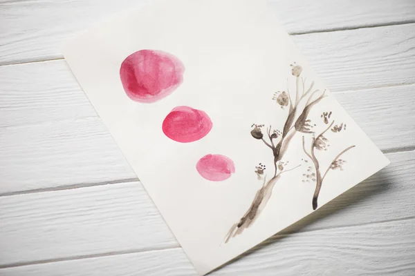 Високий кут Вид на папір з япанським живописом з рослинами і рожевими колами на дерев'яному тлі. — стокове фото