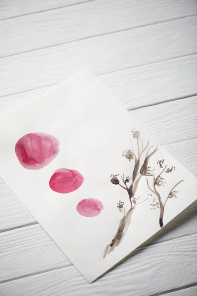 High angle view of paper with japanese painting with plant and circles on wooden background — Stock Photo