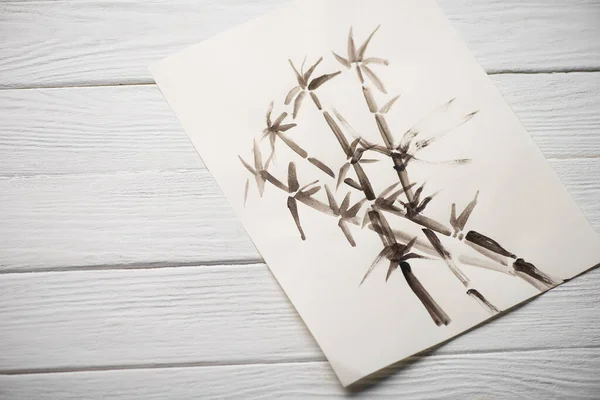 Top view of paper with japanese painting with bamboo on wooden background — Stock Photo