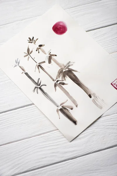 Hochwinkelansicht des Papiers mit japanischer Malerei mit Bambus und Sonne auf Holzgrund — Stockfoto