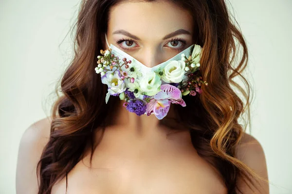 Attractive girl in floral face mask looking at camera isolated on grey — Stock Photo