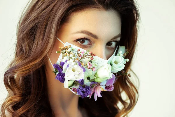 Joven atractiva mujer en la máscara facial floral mirando a la cámara aislada en blanco - foto de stock