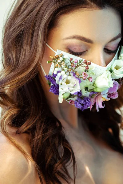 Junge attraktive Frau mit floraler Gesichtsmaske, die nach unten schaut — Stockfoto