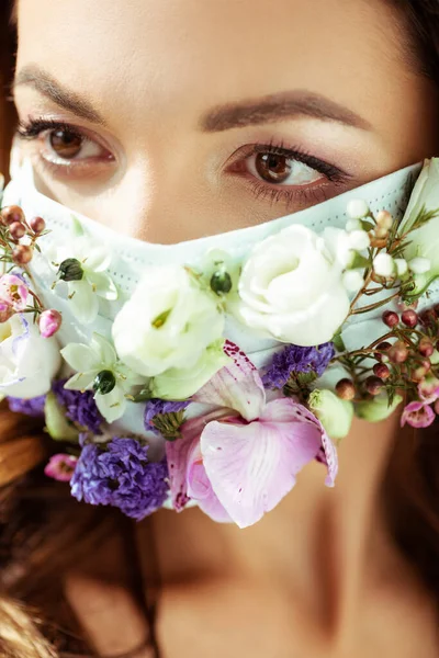 Close up de jovem mulher na máscara facial com flores — Fotografia de Stock