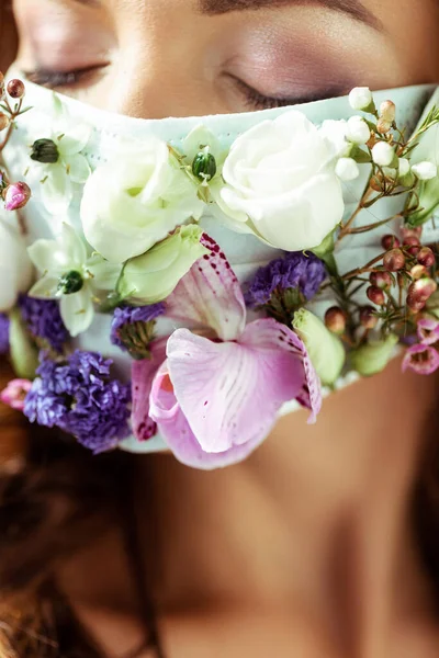 Close up of young woman with closed eyes in face mask with flowers — Stock Photo