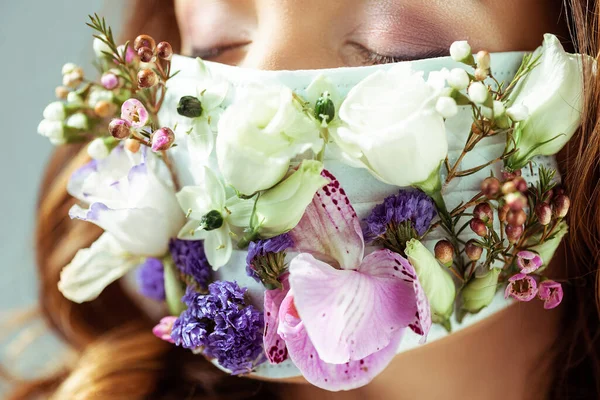 Close up of woman with closed eyes in face mask with flowers — Stock Photo