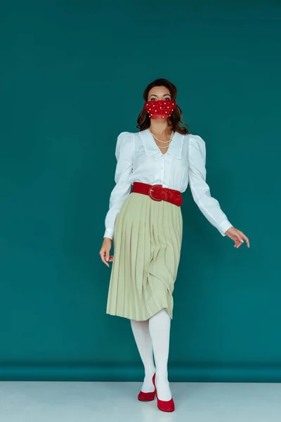 Élégant jeune femme en masque rouge posant sur le bleu — Photo de stock