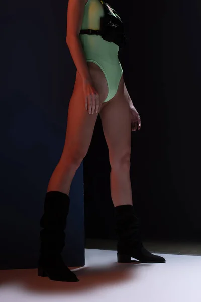 Cropped view of woman in futuristic bodysuit posing on dark — Stock Photo