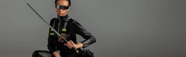 Atraente futurista mulher americana africana em óculos com espada em cinza, tiro panorâmico — Fotografia de Stock