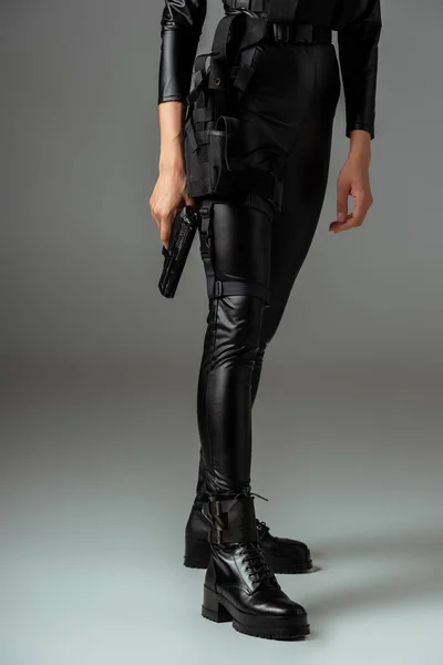 Vista parcial de mujer afroamericana futurista en gafas con pistola en gris — Stock Photo