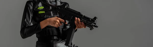 Abgeschnittene Ansicht einer futuristischen afrikanisch-amerikanischen Frau mit Sturmgewehr isoliert auf grau — Stockfoto