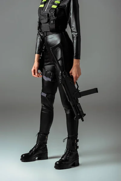 Ausgeschnittene Ansicht einer futuristischen afrikanisch-amerikanischen Frau mit Sturmgewehr auf grau — Stockfoto