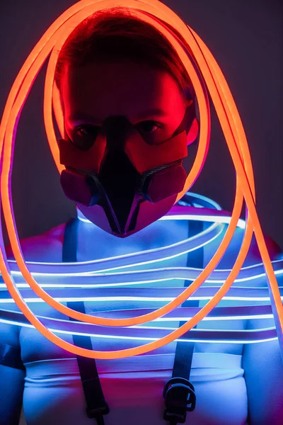 Futuristic african american woman in respirator and neon lighting — Stock Photo