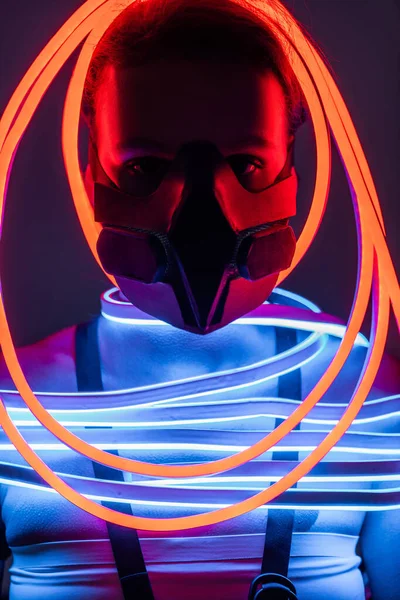 Futuristic african american woman in respirator and neon lighting — Stock Photo