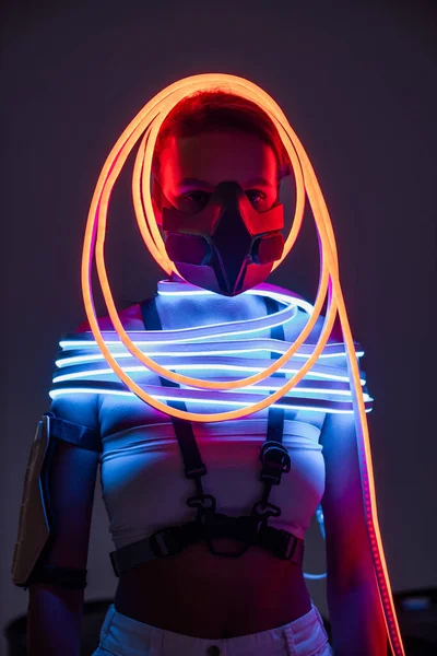 Futuristic african american woman in respirator and neon lighting — Stock Photo