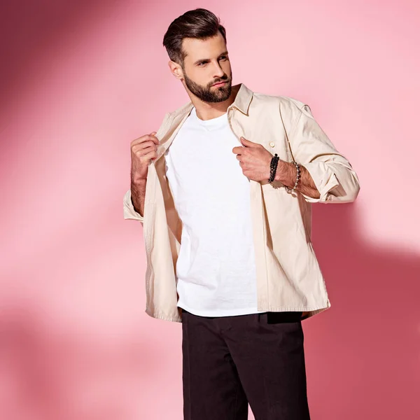 Hombre joven barbudo de moda posando en camisa de verano y pantalones cortos en rosa — Stock Photo