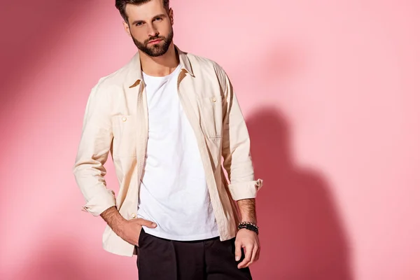 Hombre barbudo elegante posando en camisa de verano y pantalones cortos en rosa - foto de stock