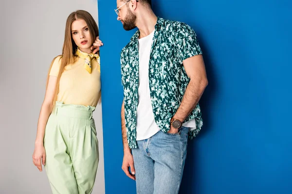 Elegante pareja joven posando en ropa de verano en gris y azul - foto de stock