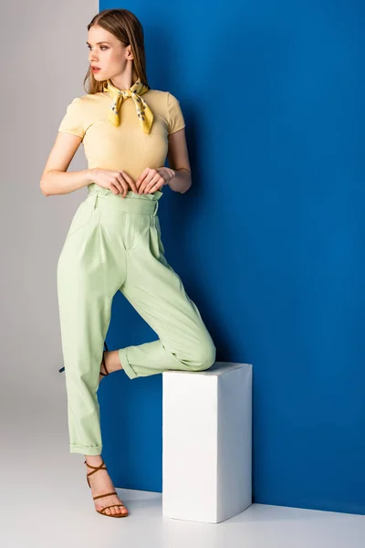 Mulher elegante atraente posando em calças de verão verdes e sandálias de salto em cinza e azul — Fotografia de Stock