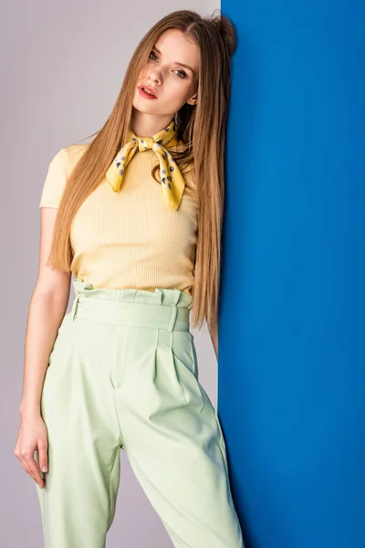 Menina elegante atraente posando em calças de verão verdes e camiseta amarela em cinza e azul — Fotografia de Stock