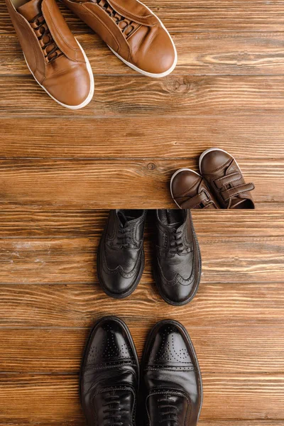 Image divisée avec des chaussures brunes et noires pour hommes et enfants sur fond en bois, concept de fête des pères — Photo de stock