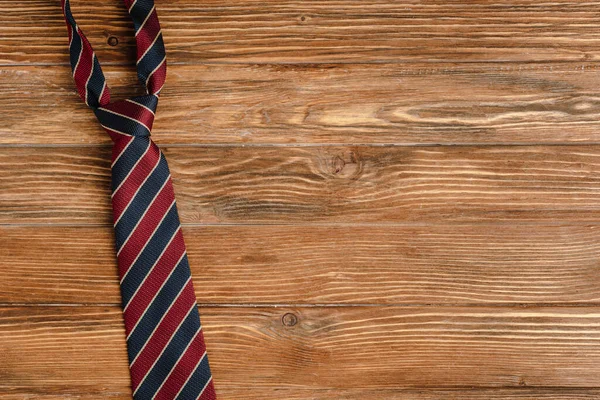 Vista dall'alto di mens cravatta a righe su sfondo di legno — Foto stock