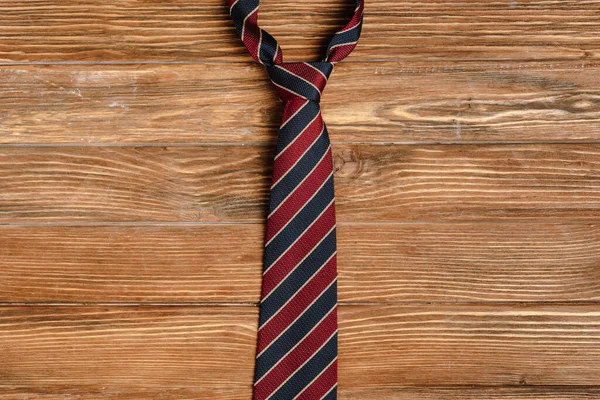 Вид зверху чоловіча смугаста тканина краватка на дерев'яному фоні — стокове фото
