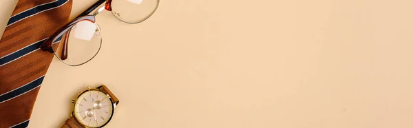 Colpo panoramico di cravatta da uomo, orologio da polso e occhiali su sfondo beige — Foto stock